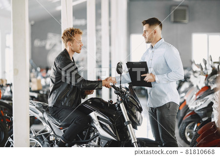 Handsome man choosing a motorcycle to buy 81810668