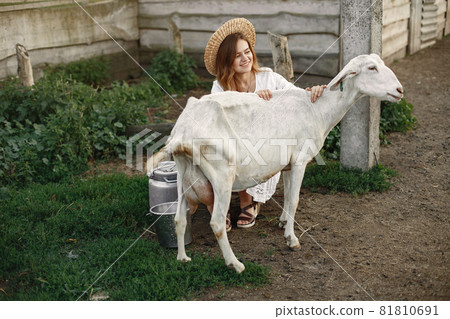 Putdoor portrait of young happy woman with goat Putdoor portrait of young happy woman with goat 81810691