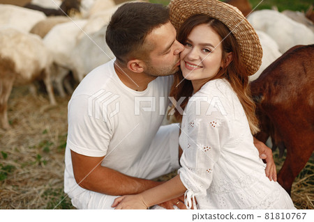 Couple spend time in a farm with goats 81810767