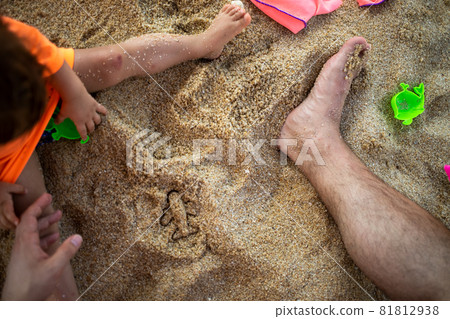 Concept Of Opening Flights Between Countries, The Abolition Of Pandemic Quarantine. Start Of Flights. parent and child play in the sand on the beach, make a plane out of the sandbox mold. top view Concept Of Opening Flights Between Countries, The Abolition Of Pandemic Quarantine. Start Of Flights. parent and child play in the sand on the beach, make a plane out of the sandbox mold. top view 81812938