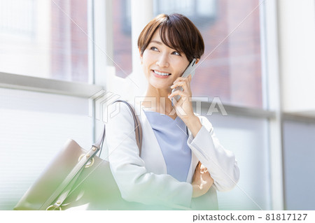 一位微笑的 Alafor 女士在用智能手機交談 81817127