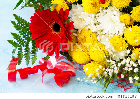 A wedding story or background Mother's Day. Basket bouquet of gerbera and chrysanthemums on a stone background or slate. 81819198