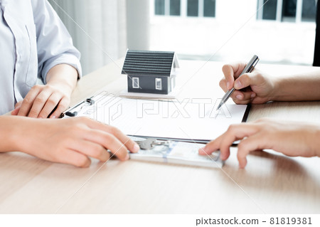 A real estate agent with rental homes and home insurance for clients to sign contracts under a formal home lease agreement. Home rental and insurance concept 81819381