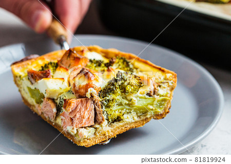 Piece of quiche pie with salmon and broccoli in plate. Piece of quiche pie with salmon and broccoli in plate. 81819924