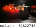 Christmas decoration with christmas bauble and candle for advent season four candles burning on black background 81822748