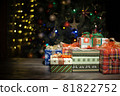 Beautiful Christmas gifts on a table at home and tree with lights in the background, festivity and holiday concept 81822752