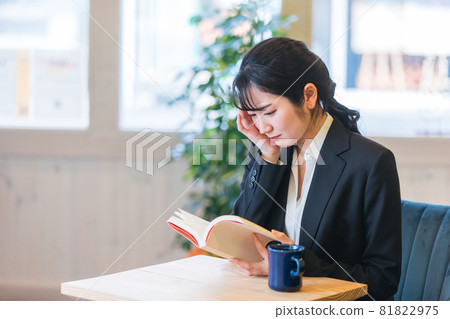 A woman reading a book at a cafe (crying) A woman reading a book at a cafe (crying) 81822975