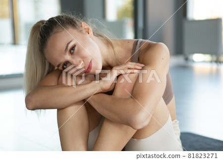 Close-up shot of smiling young girl with long hair sitting at yoga meditation center. Concept of healthy lifestyle, wellbeing, mental health 81823271