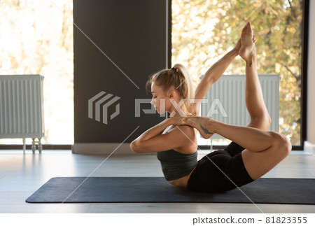 Yoga master. Portrait of young slim sportive woman in sportswear doing exercise on sports mat at yoga meditation center. Concept of healthy lifestyle, wellbeing, mental health Yoga master. Portrait of young slim sportive woman in sportswear doing exercise on sports mat at yoga meditation center. Concept of healthy lifestyle, wellbeing, mental health 81823355