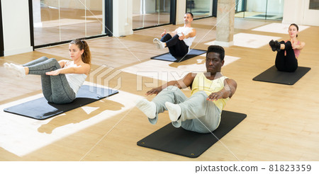 Sporty people doing pilates exercises in fitness studio Sporty people doing pilates exercises in fitness studio 81823359