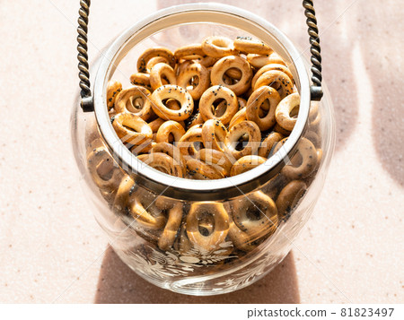 Sushki with poppy seeds (traditional Eastern European crunchy bread rings) in vintage glass jar on window sill in home kitchen Sushki with poppy seeds (traditional Eastern European crunchy bread rings) in vintage glass jar on window sill in home kitchen 81823497