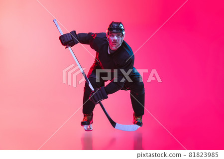 One man, professional hockey player in uniform training isolated over gradient pink background in neon. Goalkeeper. Full-length portrait One man, professional hockey player in uniform training isolated over gradient pink background in neon. Goalkeeper. Full-length portrait 81823985