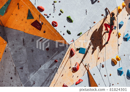 One Caucasian man professional rock climber practicing alone at training center in sunny day, outdoors. Concept of healthy lifestyle, tourism, nature, motion. 81824301