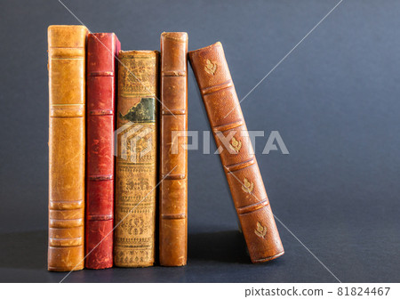 Row of old books on dark background Row of old books on dark background 81824467
