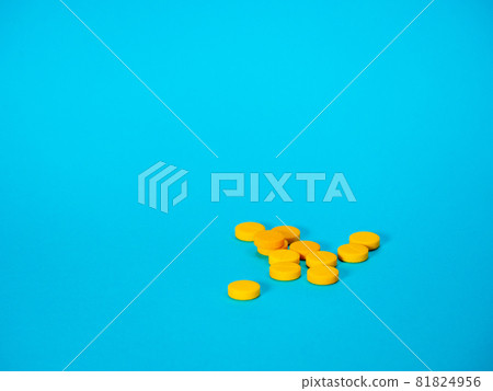 Yellow pills on blue background Yellow pills on blue background 81824956