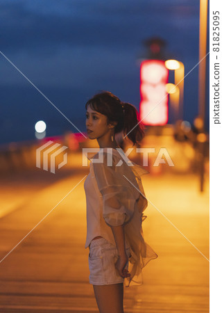 Woman on the beach at dusk 81825095