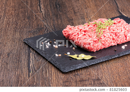 Minced meat on a stone board with thyme and spices. 81825603