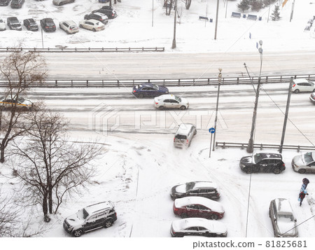 above view of cars drive from urban yard to street in snowfall in Moscow city in snowy winter day above view of cars drive from urban yard to street in snowfall in Moscow city in snowy winter day 81825681