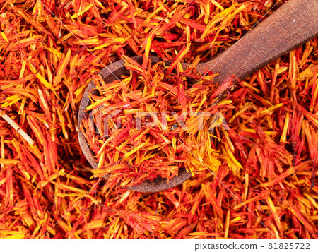 top view of wood spoon on pile of dried safflower petals closeup top view of wood spoon on pile of dried safflower petals closeup 81825722