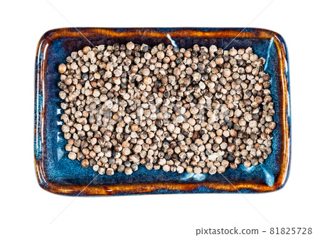 top view of monk's pepper (Vitex) on rectangular plate cutout on white background 81825728