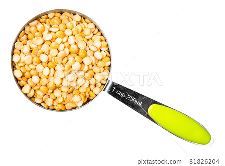 top view of dried split yellow peas in measuring cup cutout on white background 81826204