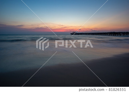 The shadow of the harbour bridge. Sunset, orange sky, the sea and the beach reflect the orange light. Natai Beach in Phang Nga Province, Thailand 81826331