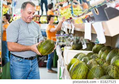 Glad man is choosing ripe melon in the store 81827525