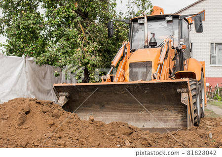 Excavator or bulldozer bucket flattens the ground or road in the industrial zone or construction site Excavator or bulldozer bucket flattens the ground or road in the industrial zone or construction site 81828042