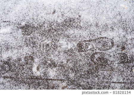 top view of frozen footprints on ice-covered path after freezing rain on cold autumn day top view of frozen footprints on ice-covered path after freezing rain on cold autumn day 81828134