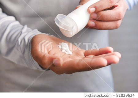 man applying beauty cream onto skin  81829624