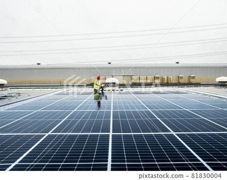 male engineer checks a photovoltaic (solar) plant and uses a recording tablet. mechanic in protective helmet. Man in uniform holding tablet.. male engineer checks a photovoltaic (solar) plant and uses a recording tablet. mechanic in protective helmet. Man in uniform holding tablet.. 81830004