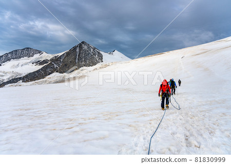 Group of mountaineers on a rope. Summer glacier trekking on Grossvenediger Mountain, Hohe Tauern National Park, Austrian Alps Group of mountaineers on a rope. Summer glacier trekking on Grossvenediger Mountain, Hohe Tauern National Park, Austrian Alps 81830999