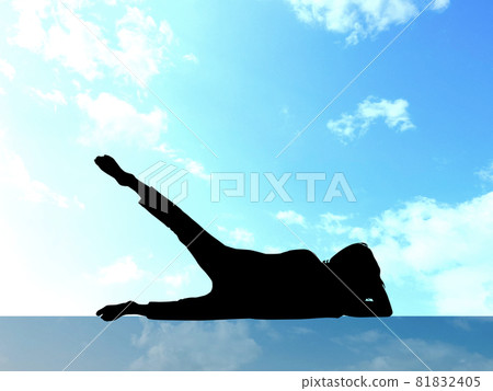 Female silhouette lying down and raising legs_blue sky background 81832405