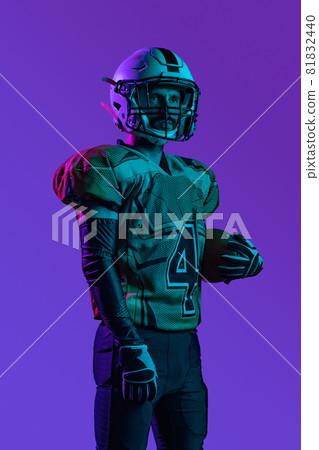 One professional american footbal player in special unofrm isolated over purple studio background 81832440