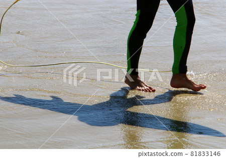 a man walks barefoot along a sandy beach on the shores of the mediterranean sea a man walks barefoot along a sandy beach on the shores of the mediterranean sea 81833146