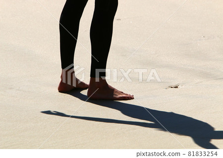 a man walks barefoot along a sandy beach on the shores of the mediterranean sea 81833254