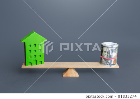 Green house and money on the scales. Evaluation of savings on energy and utilities in an efficient eco building. Building maintenance. Renovation improvement of old buildings. Profitability 81833274