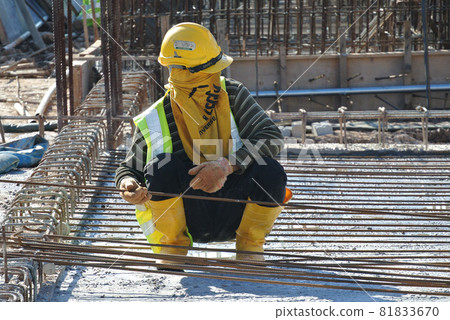 MALACCA, MALAYSIA -JUNE 27, 2016: Construction workers fabricating steel reinforcement bar at the construction site in Malacca, Malaysia. The reinforcement bar was ties together using tiny wire.   81833670