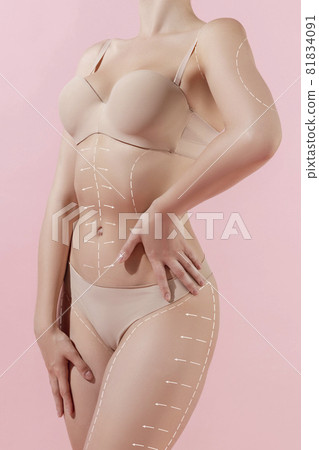 Cropped image of tanned young fit woman posing isolated over light pink studio background. The fitness, diet, sports, plastic surgery concept. Collage, flyer Cropped image of tanned young fit woman posing isolated over light pink studio background. The fitness, diet, sports, plastic surgery concept. Collage, flyer 81834091