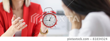 Manager shows alarm clock to subordinate, fixing delay for work 81834324