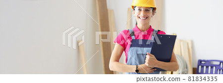 Smiling woman builder holds clipboard with documents in her hands 81834335