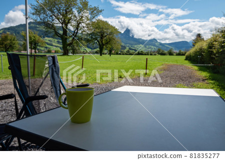 Camping table and chairs in the Switzerland Alps. Great view. Outdoor camping concept Camping table and chairs in the Switzerland Alps. Great view. Outdoor camping concept 81835277