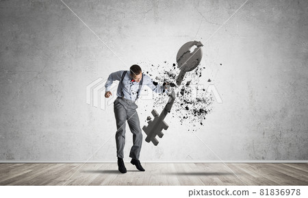 Breaking through access concept with man in room crashing concrete key 81836978