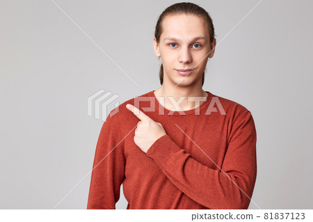 young man pointing finger away at empty space young man pointing finger away at empty space 81837123