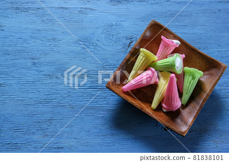 Candy on wooden tableware on a blue wood background 81838101