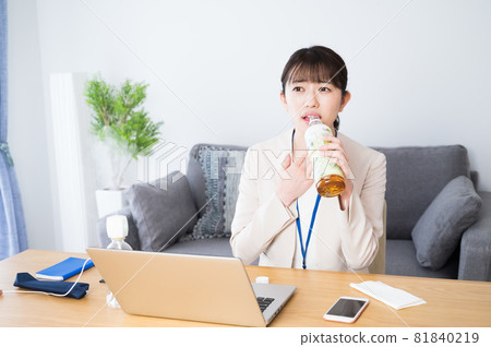 A woman who drinks tea at work to moisturize her throat A woman who drinks tea at work to moisturize her throat 81840219