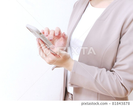 A woman in a suit manipulating a smartphone A woman in a suit manipulating a smartphone 81843878