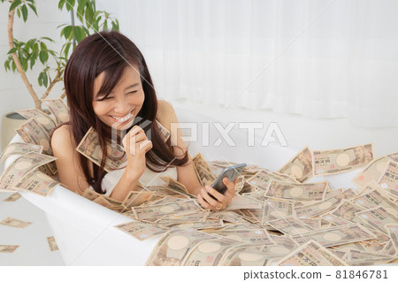 A woman who gets profit information on her smartphone and takes a wad of bills 81846781