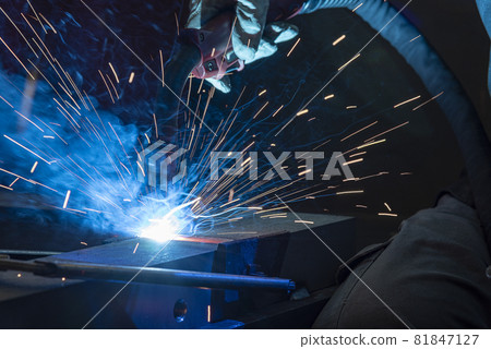 Industrial steel welder in factory. welder with protective mask welding metal and sparks Industrial steel welder in factory. welder with protective mask welding metal and sparks 81847127