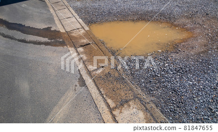 Puddle in a gravel parking lot 81847655